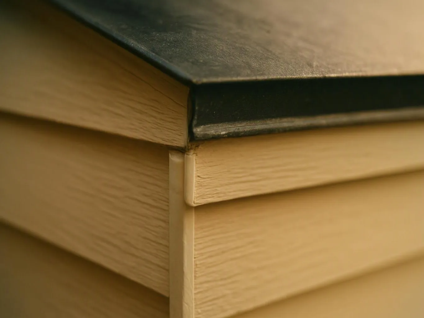 Close-up of a light wood box corner with a dark lid and visible joinery